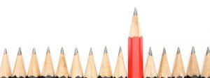 One red pencil rising above a field of same-sized pencils