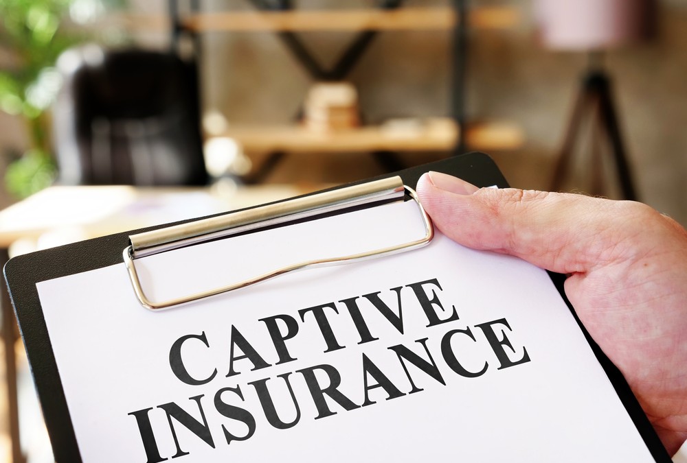 Hand Holds Captive Insurance Documents