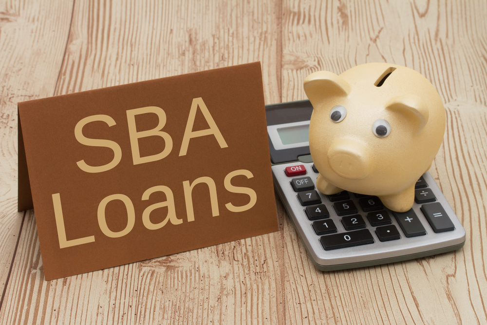 SBA Loans Sign with Calculator and Piggy Bank